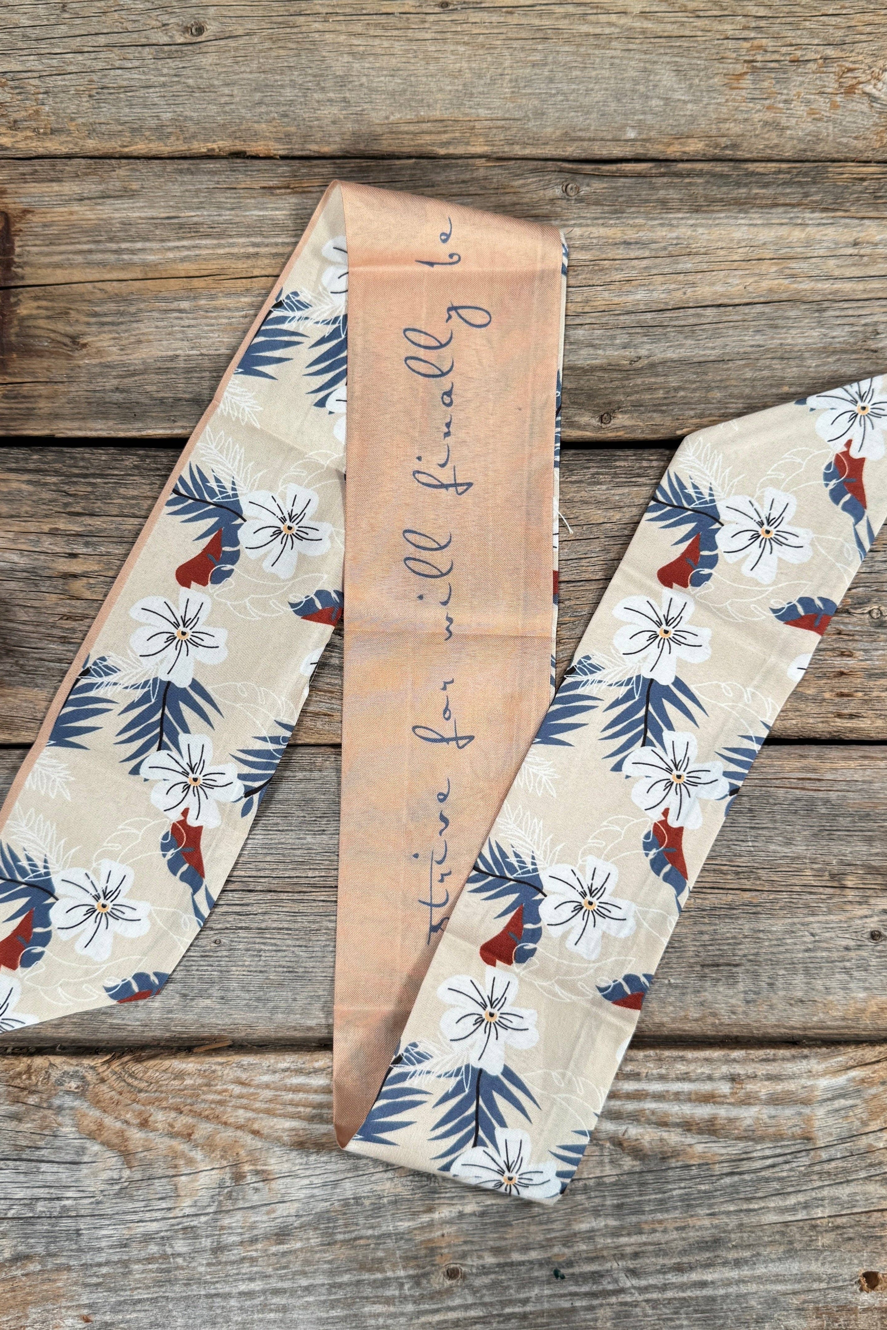 Decorative fabric scarf with floral patterns on a wooden surface