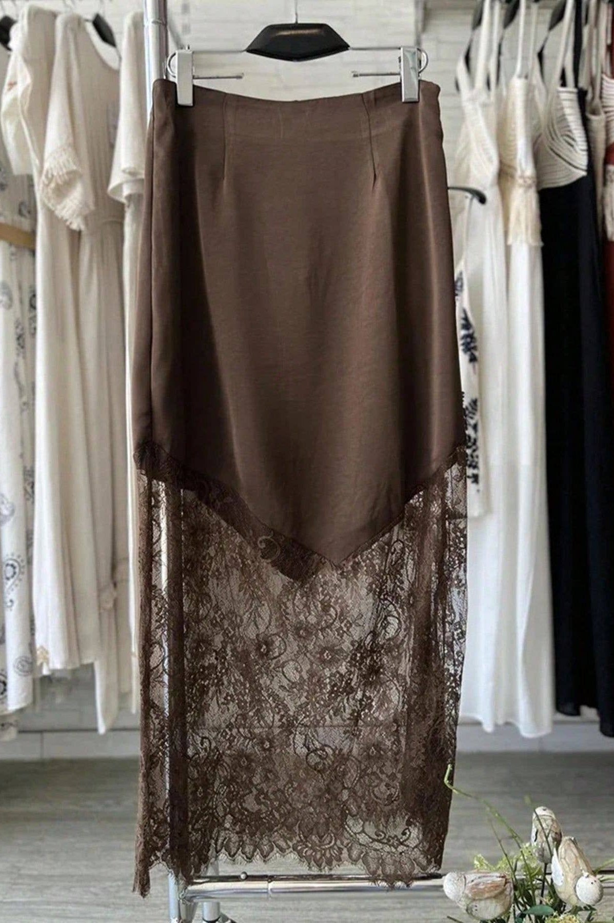 Brown skirt with lace detailing on a rack in a clothing store