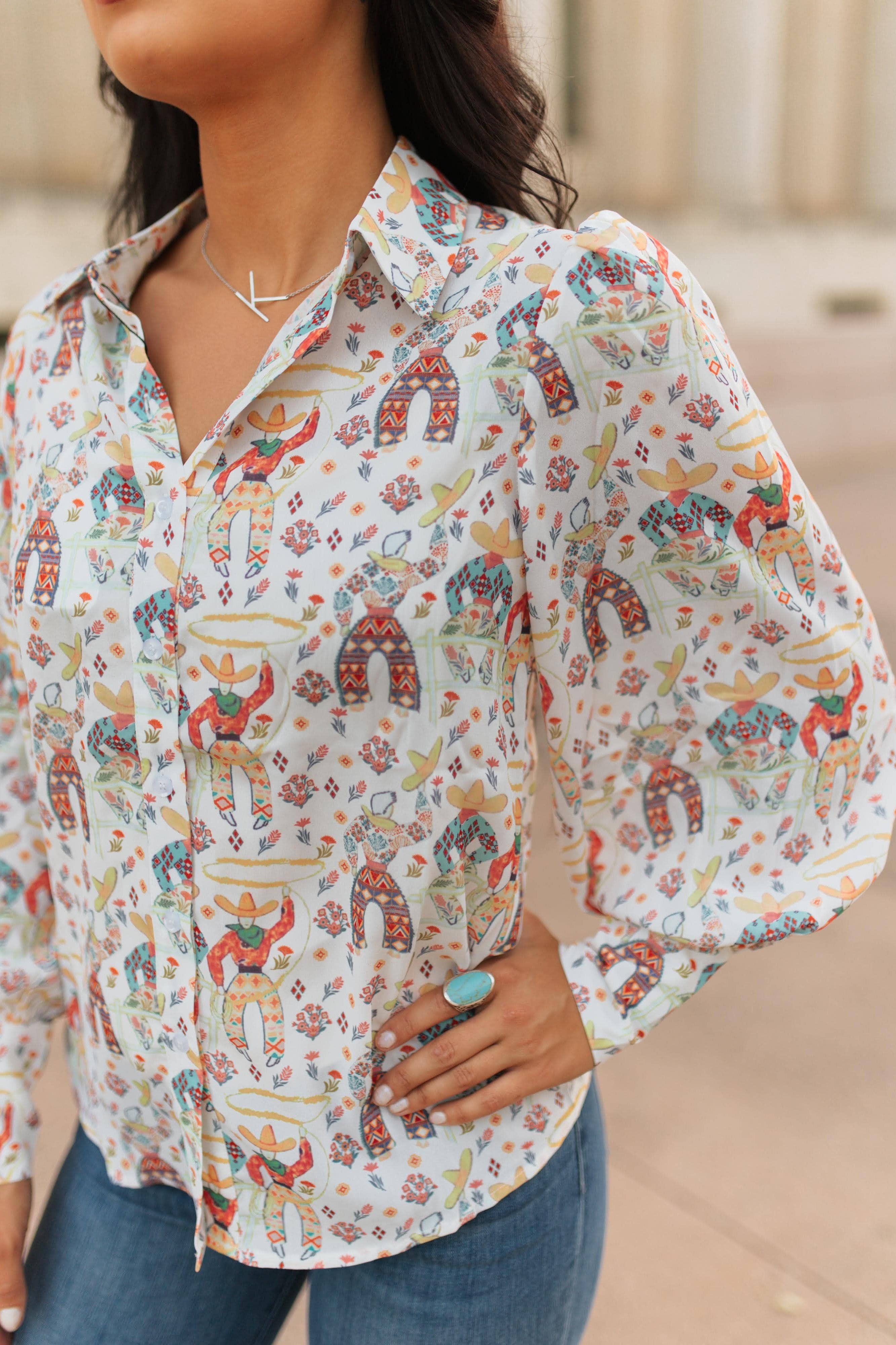 Person wearing a colorful patterned shirt with long sleeves, standing outdoors.