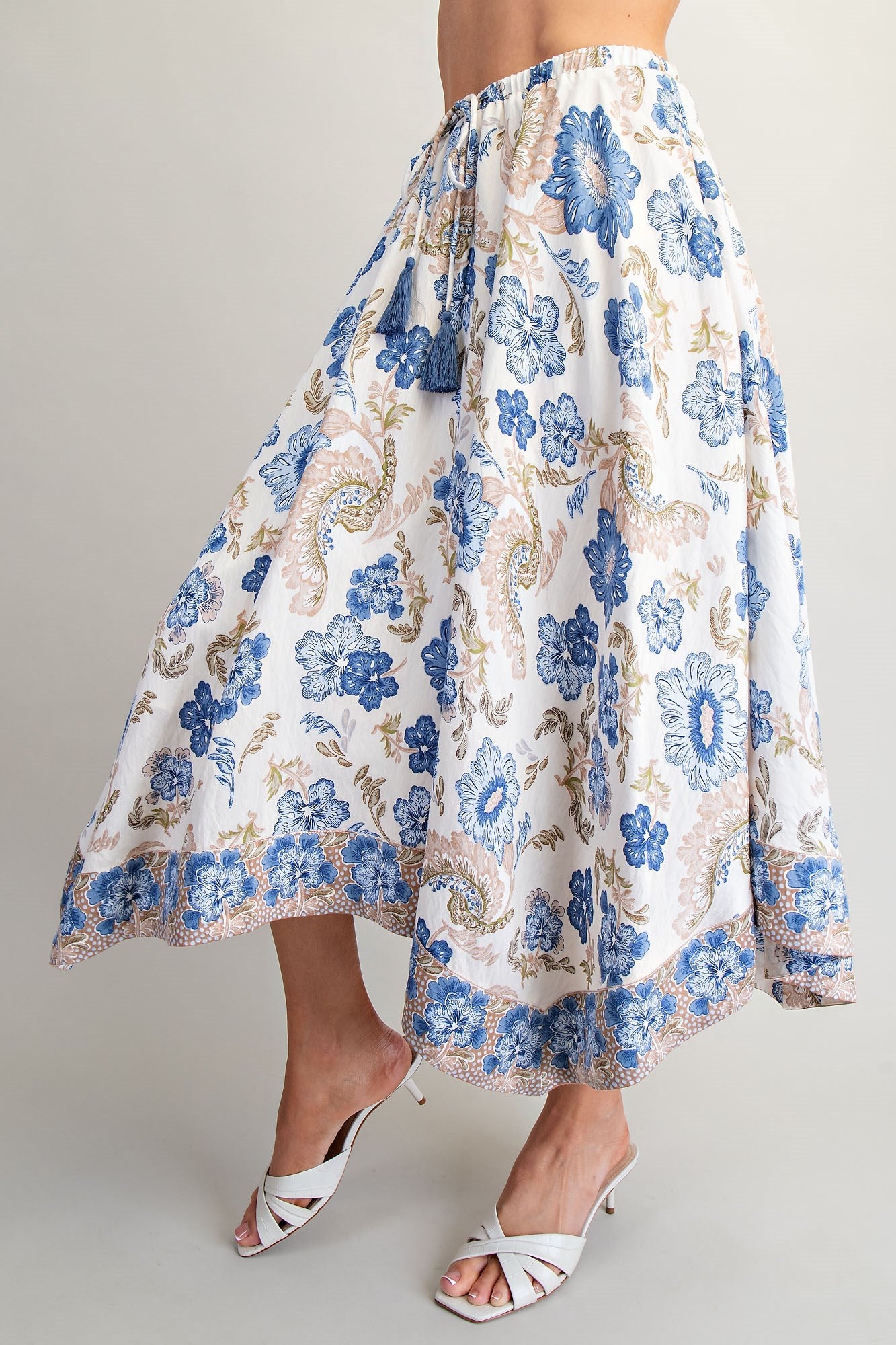 Floral patterned skirt with blue and white flowers on a plain background