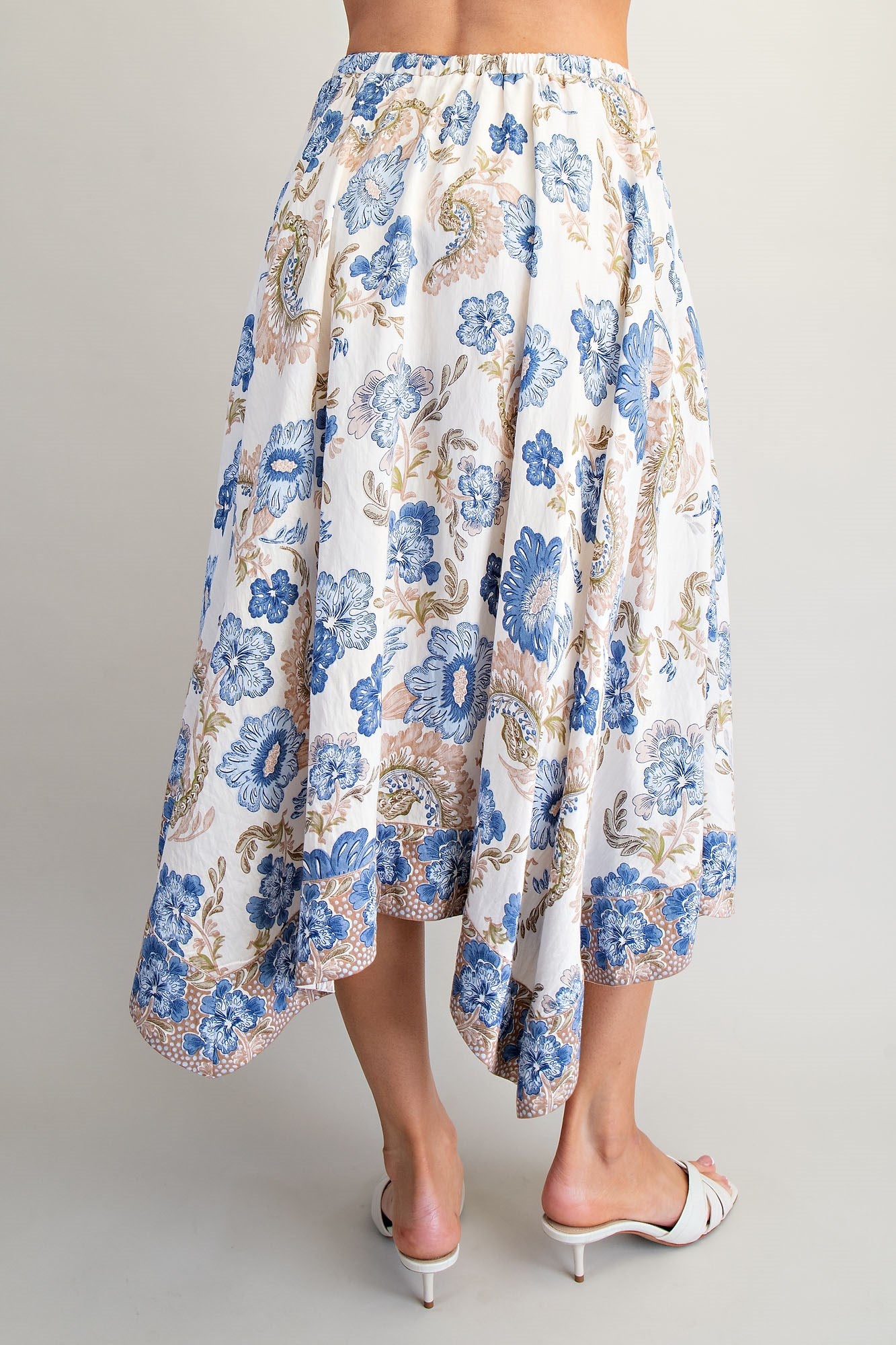 Floral patterned skirt worn by a person on a plain background