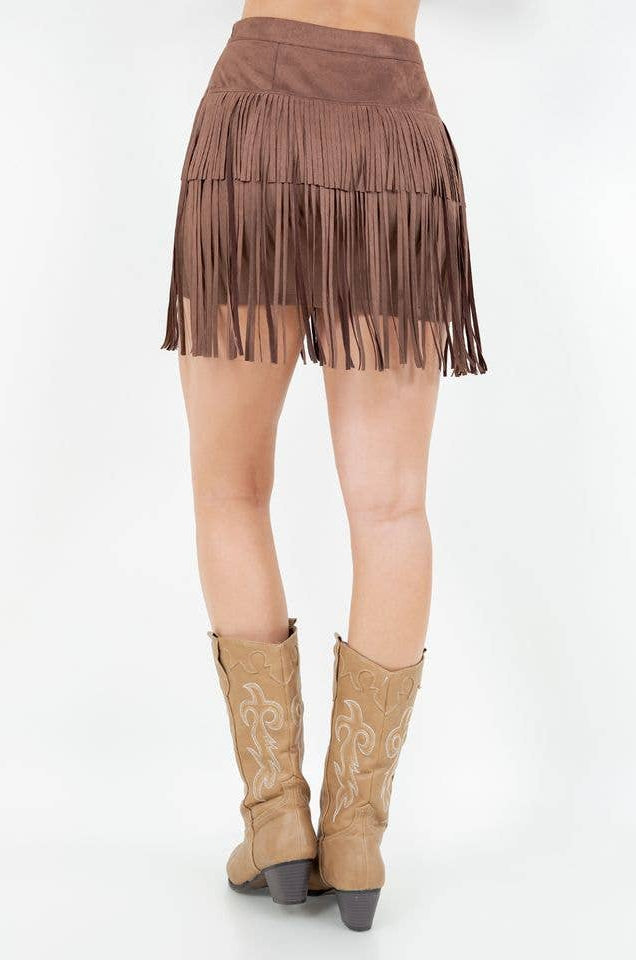 Brown fringe skirt and tan cowboy boots on a white background