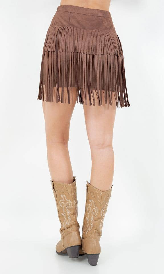 Brown fringe skirt and tan cowboy boots on a white background