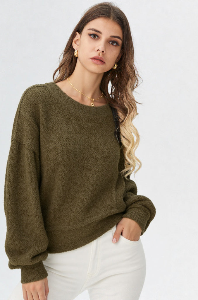 Woman in a olive round-neck textured knit oversized top with drop shoulders and long sleeves, relaxed fit
