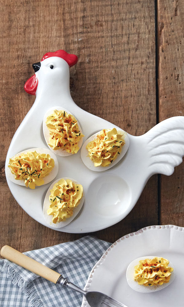 Chicken-shaped plate with deviled eggs on a wooden surface