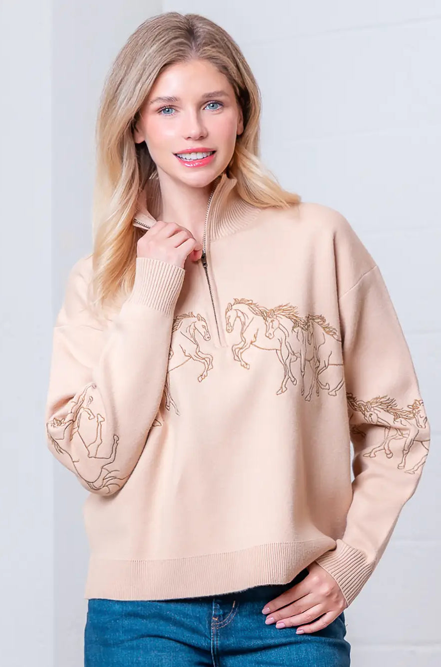 Taupe high-neck quarter-zip sweater with horse embroidery on model, front view.