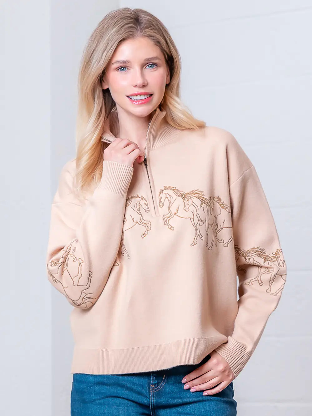 Taupe high-neck quarter-zip sweater with horse embroidery on model, front view.