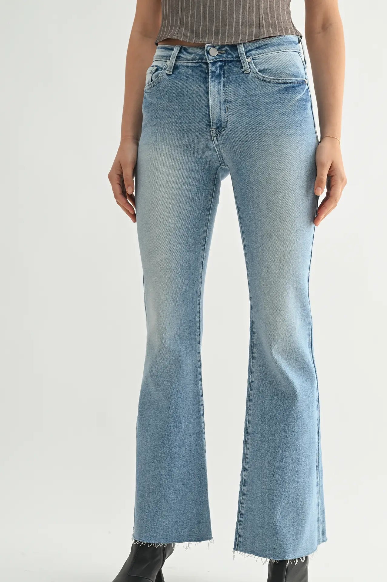 Light blue flared jeans worn by a person on a white background