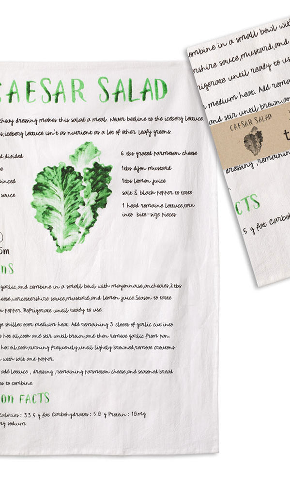 Caesar salad recipe on a tea towel with a matching tea towel on a white background