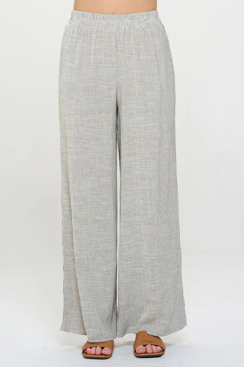 Light gray pin stripped pants worn with elastic waist by a person