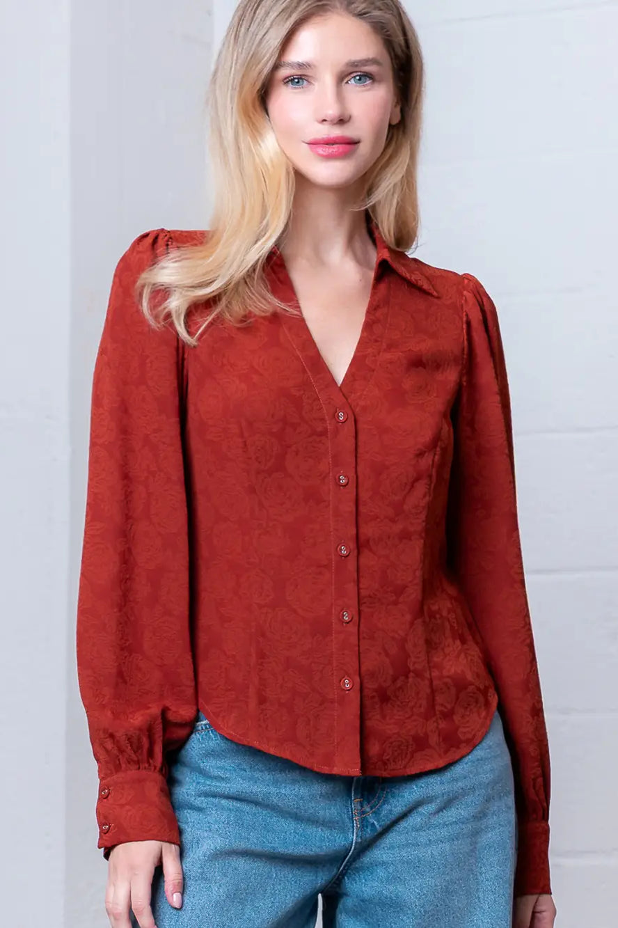 Front view of rust Western-inspired embossed blouse showing tailored waist and button front.