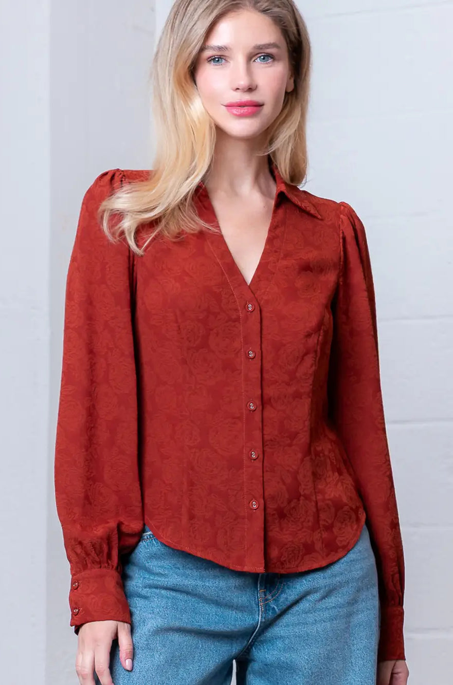 Front view of rust Western-inspired embossed blouse showing tailored waist and button front.