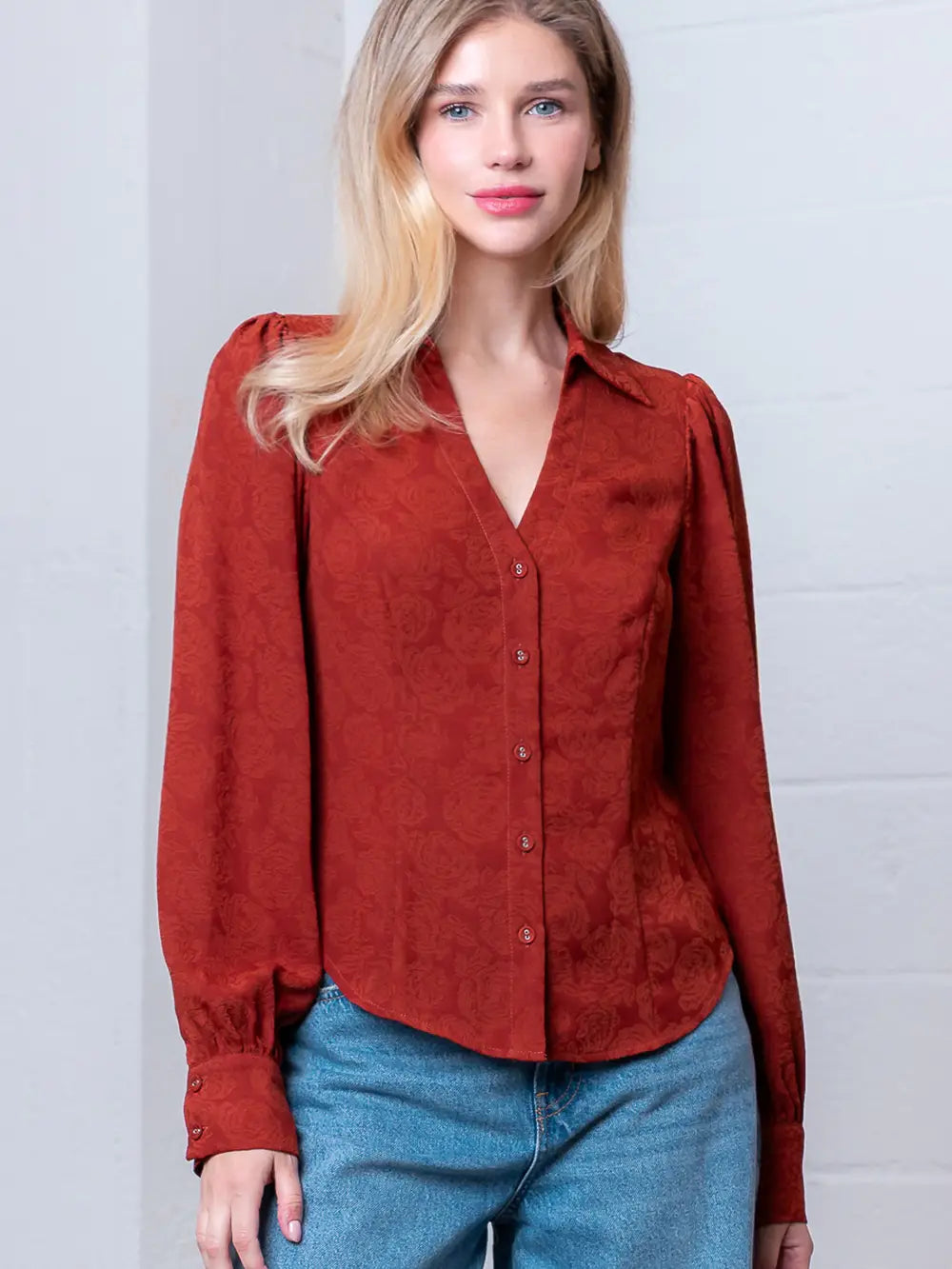 Front view of rust Western-inspired embossed blouse showing tailored waist and button front.