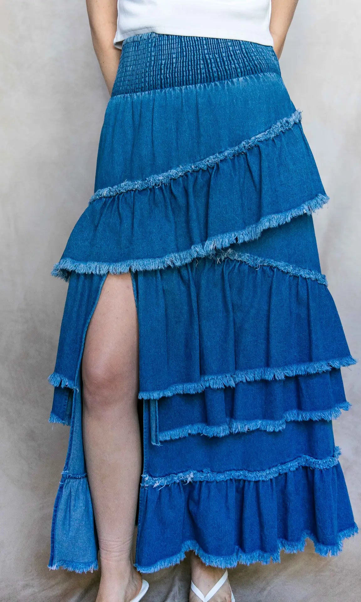 Blue tiered skirt worn by a person on a plain background