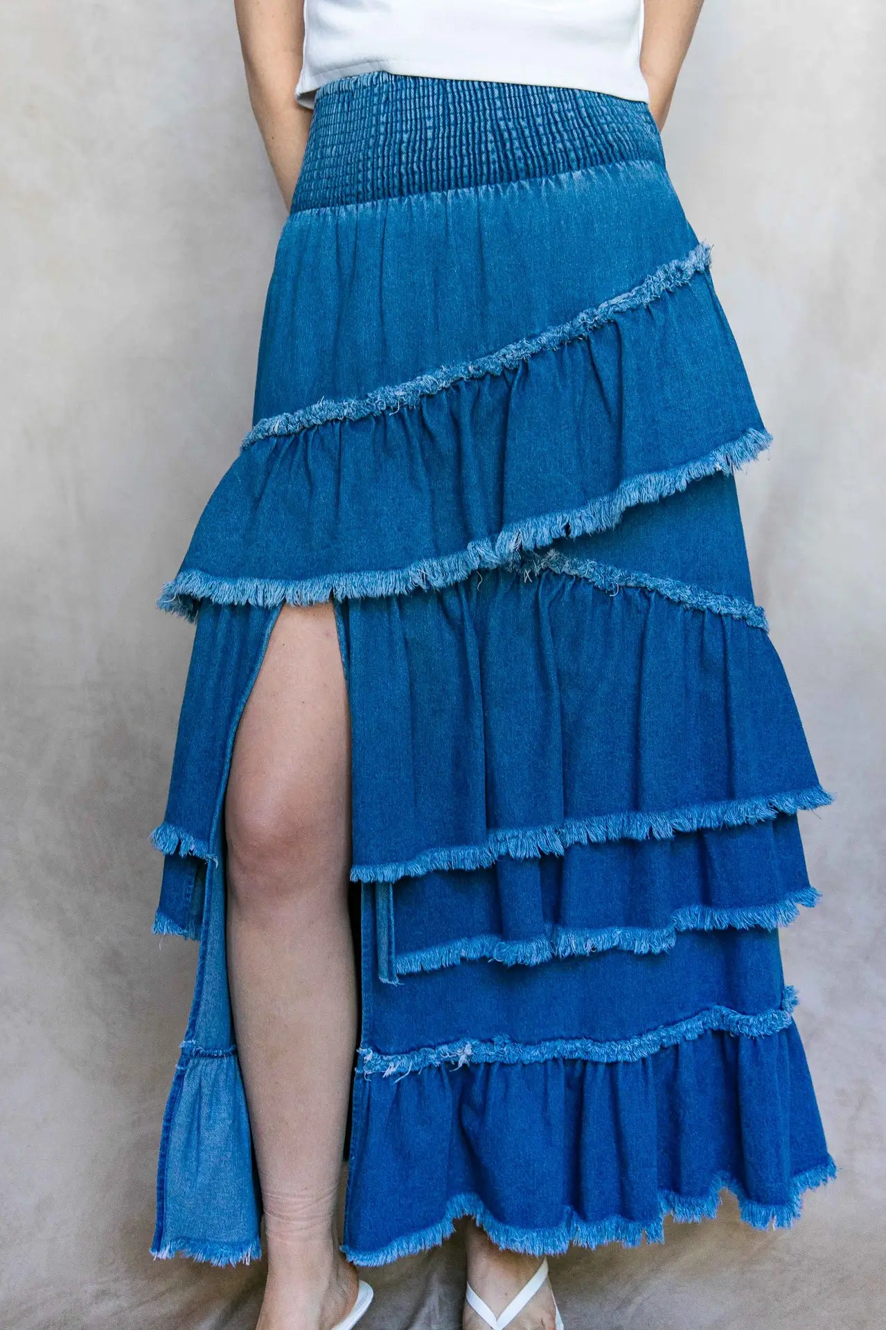 Blue tiered skirt worn by a person on a plain background