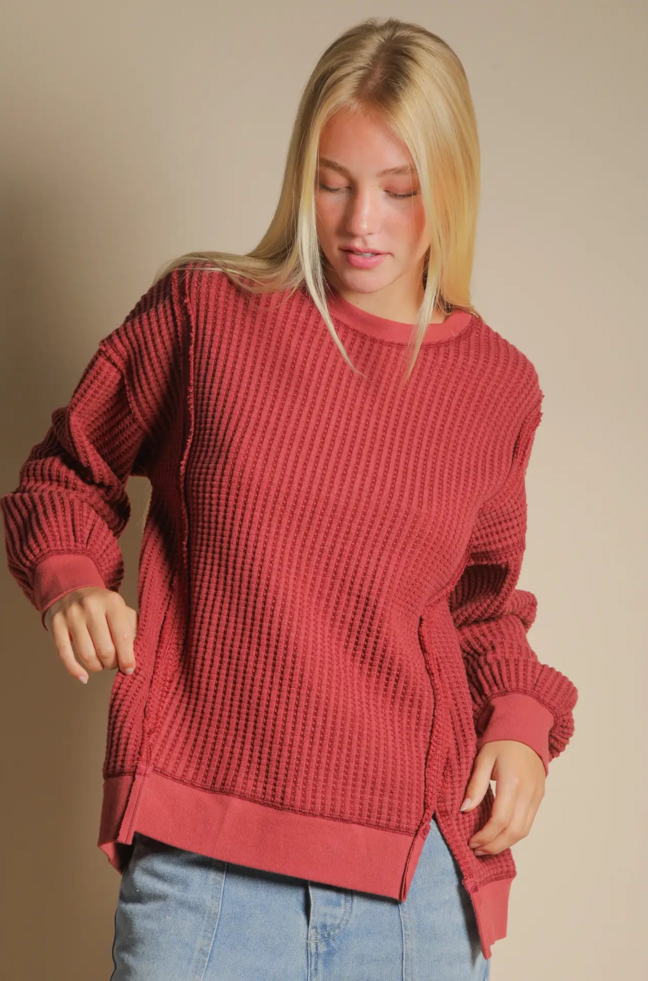 Front view of burgundy oversized waffle knit top with round neck and drop shoulders.