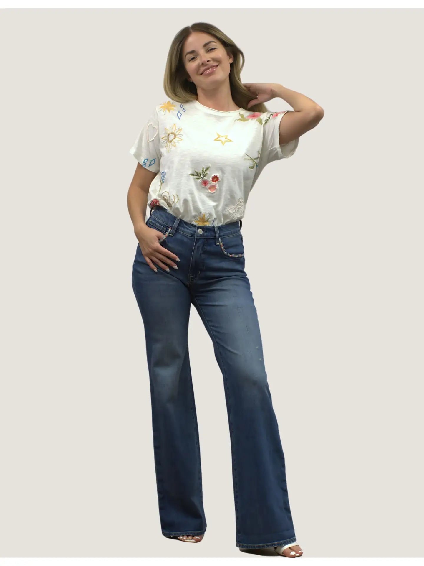 Woman wearing blue jeans with embroidery on the pocket edges