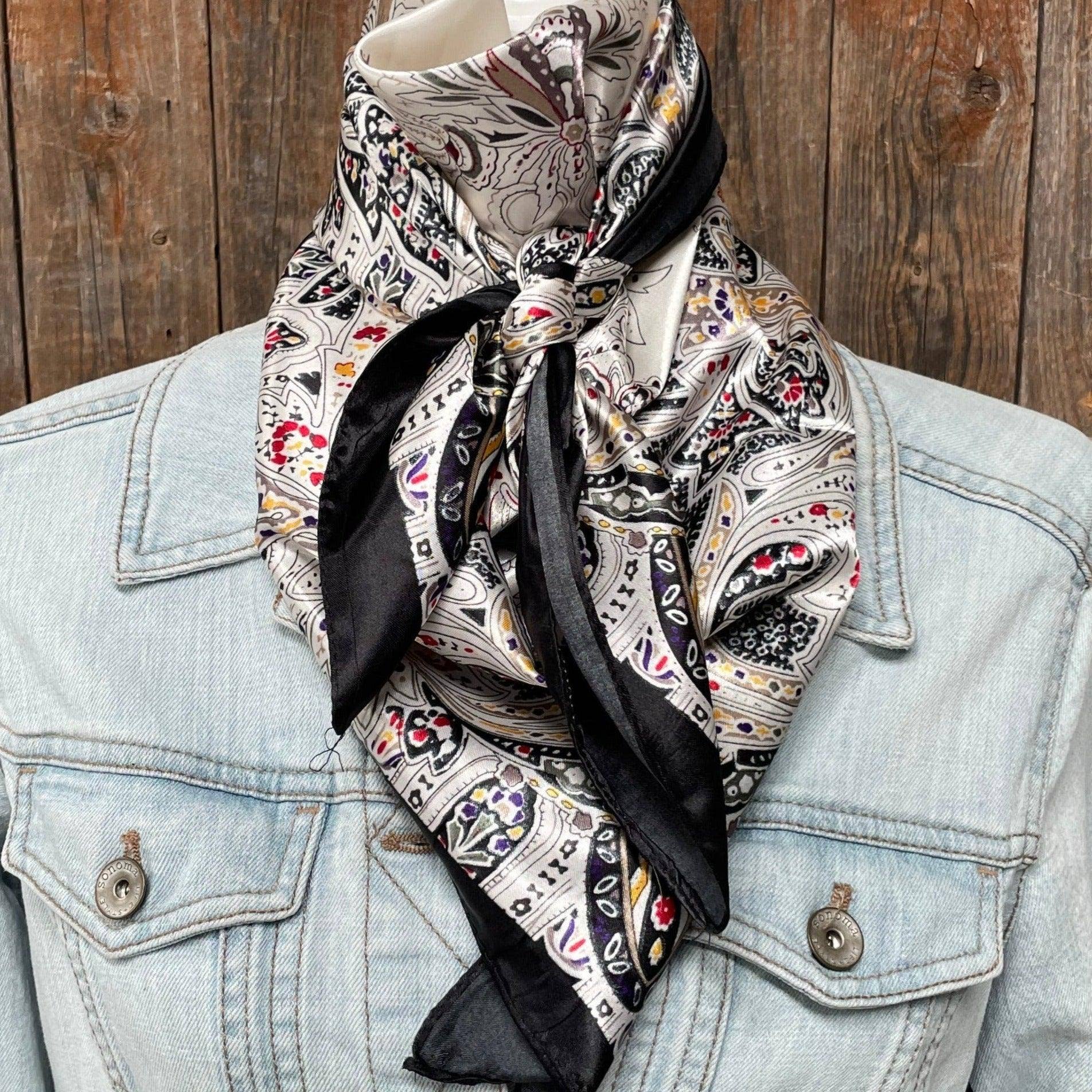Patterned scarf draped over a denim jacket against a wooden background