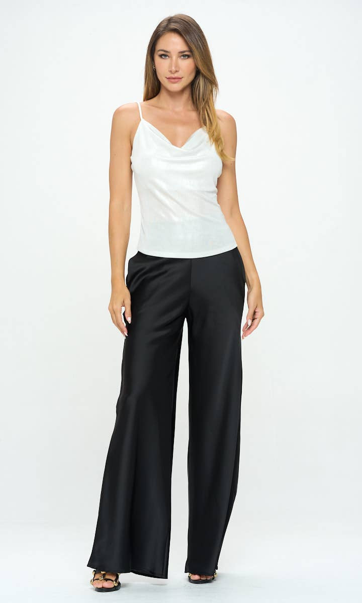 Woman wearing a white sleeveless top and black wide-leg pants on a white background