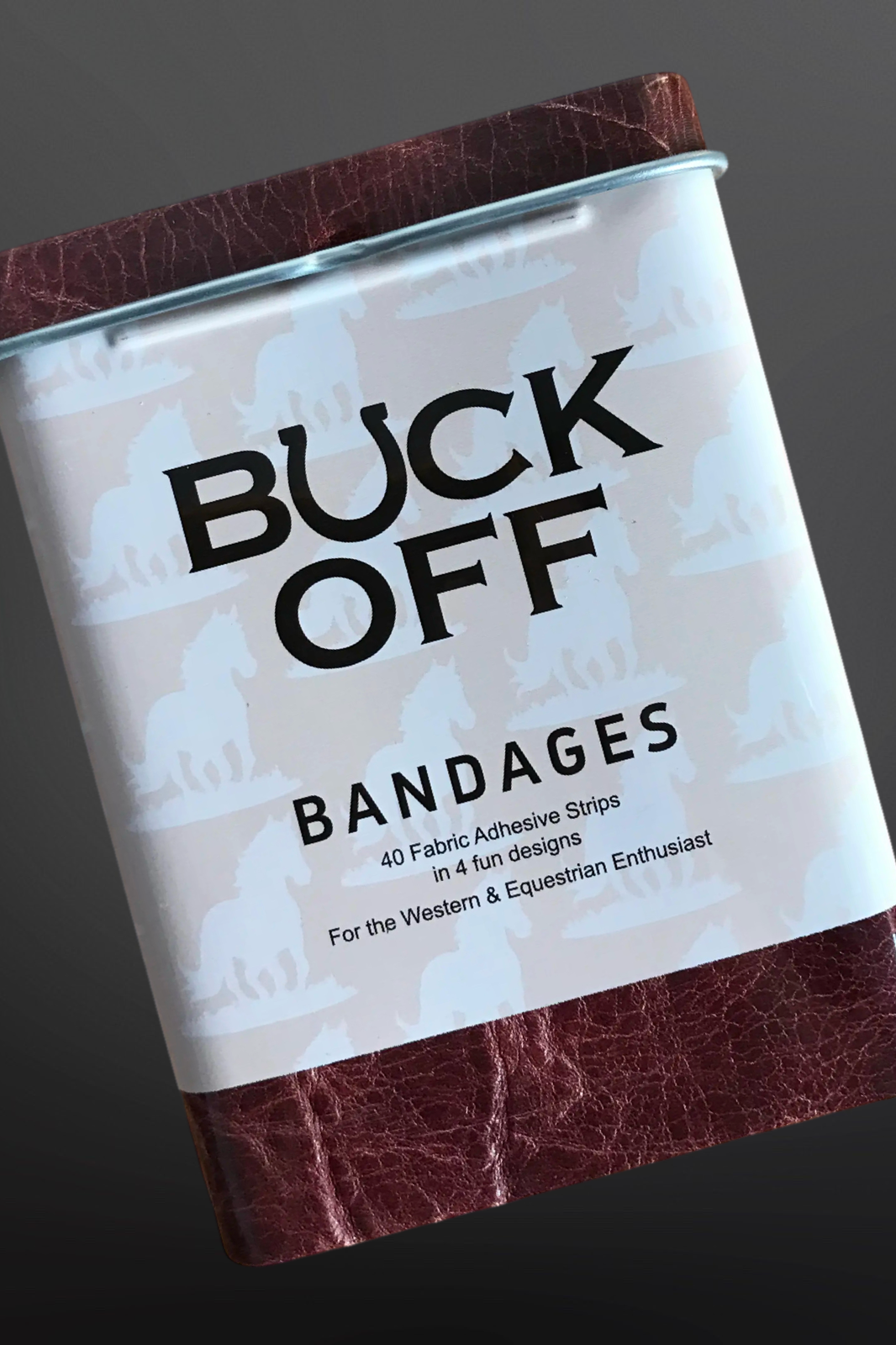 Can of Buck Off bandages with a brown lid and leather-like bottom on a dark background