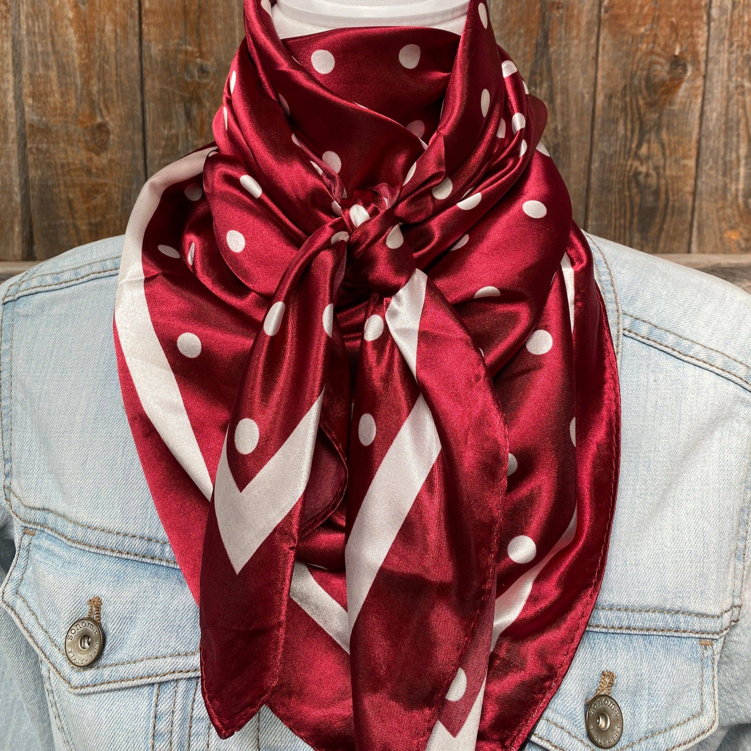 Red polka dot scarf worn by a person with a denim jacket against a wooden background