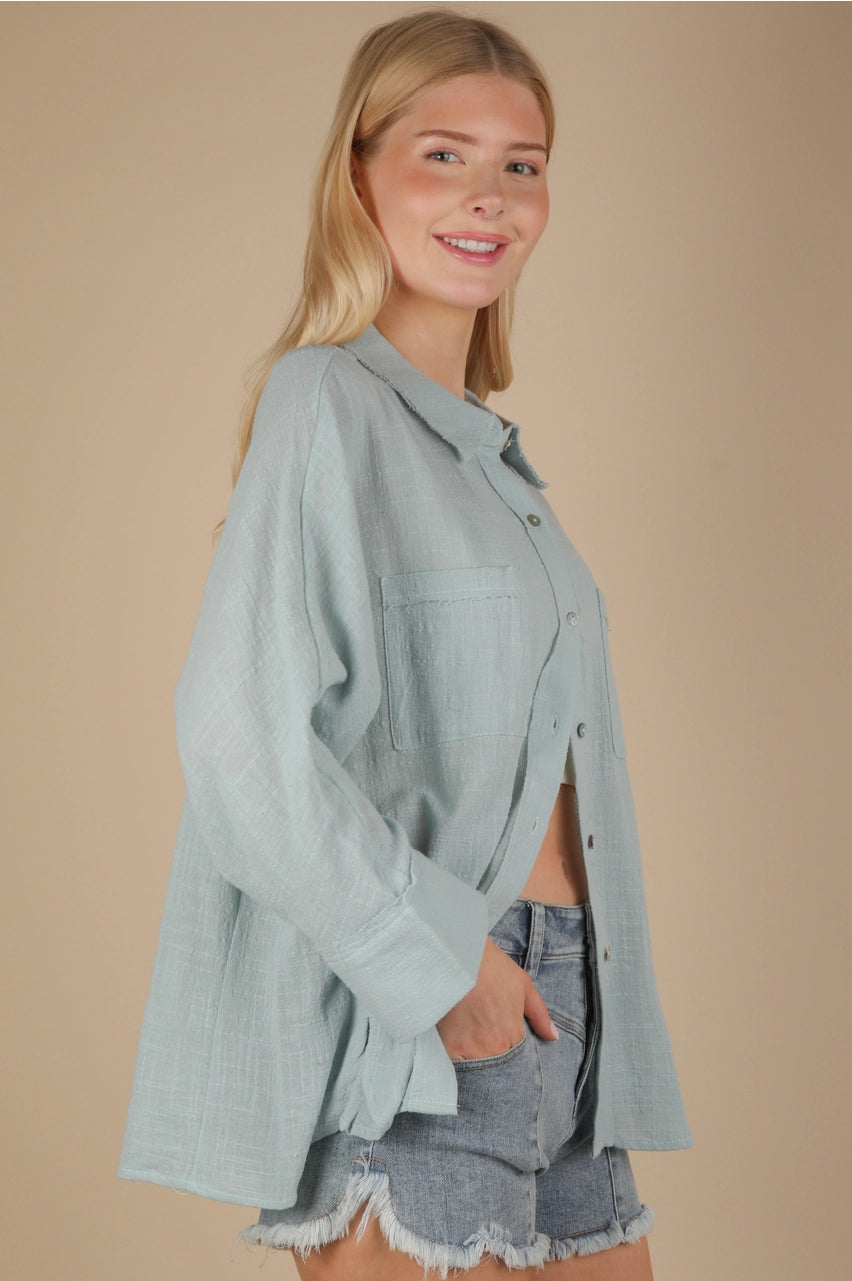 Side angle showing relaxed fit and side slit on sky blue gauze top