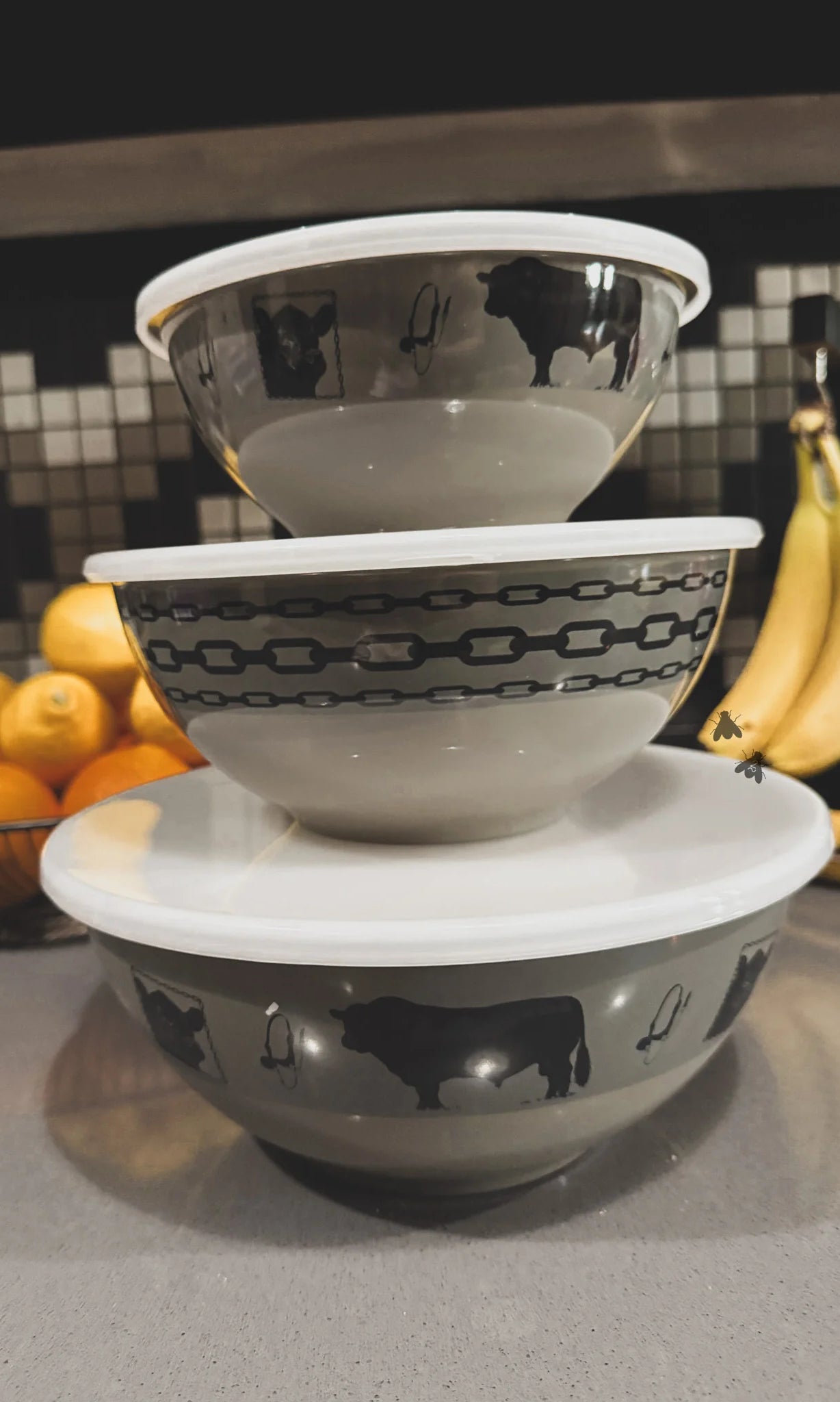 Stack of melamine bowls with black angus cow patterns on a kitchen counter