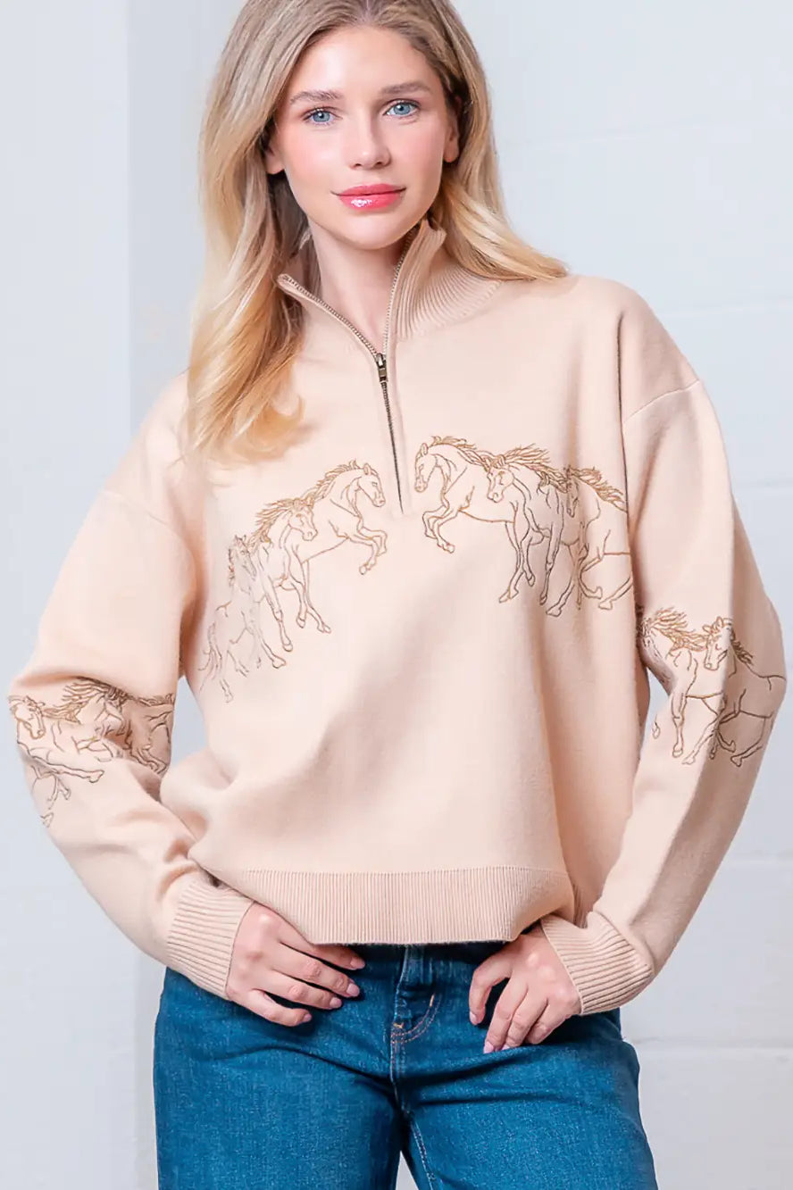 Taupe high-neck quarter-zip sweater with horse embroidery on model, front view.