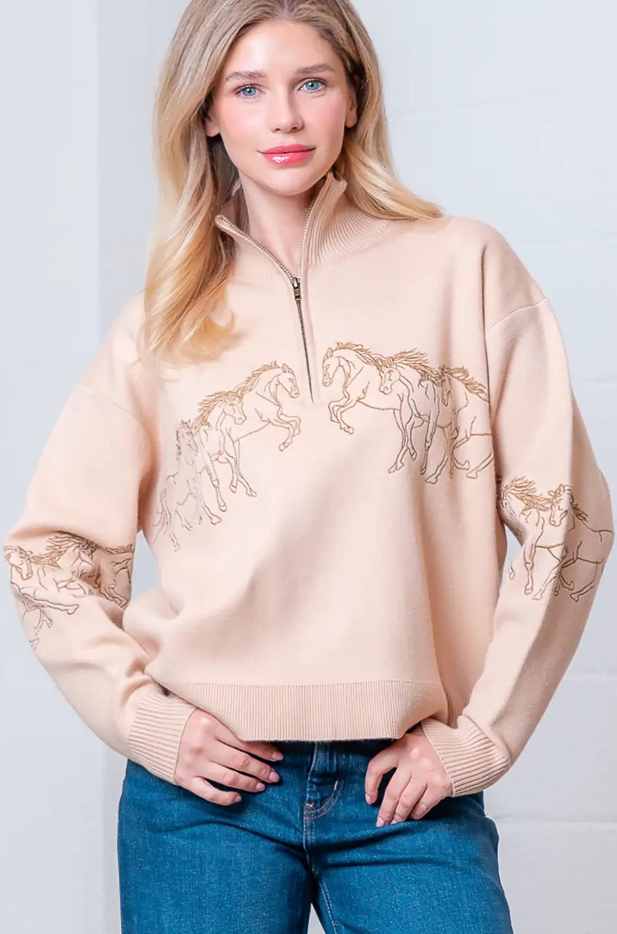 Taupe high-neck quarter-zip sweater with horse embroidery on model, front view.