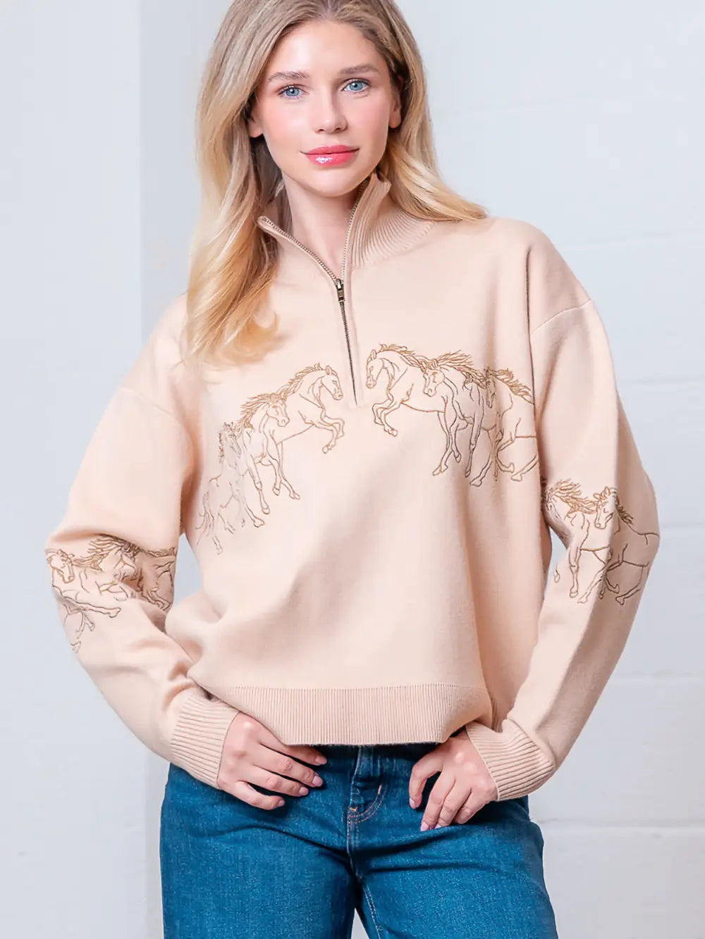 Taupe high-neck quarter-zip sweater with horse embroidery on model, front view.