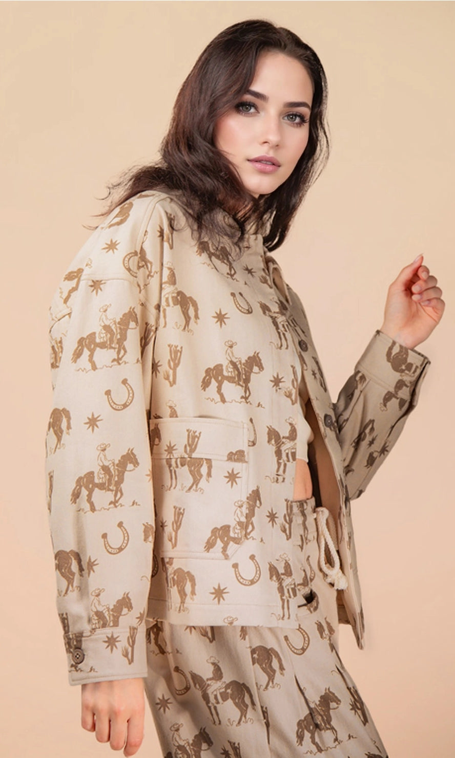 Woman wearing a beige outfit with horse pattern on a beige background