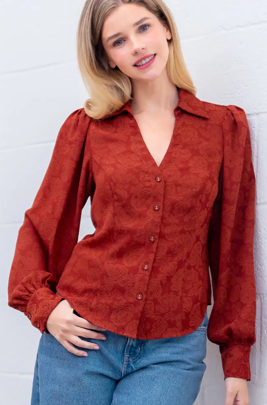 Front view of rust Western-inspired embossed blouse showing tailored waist and button front.