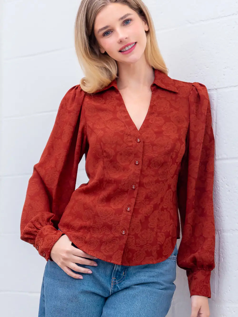 Front view of rust Western-inspired embossed blouse showing tailored waist and button front.