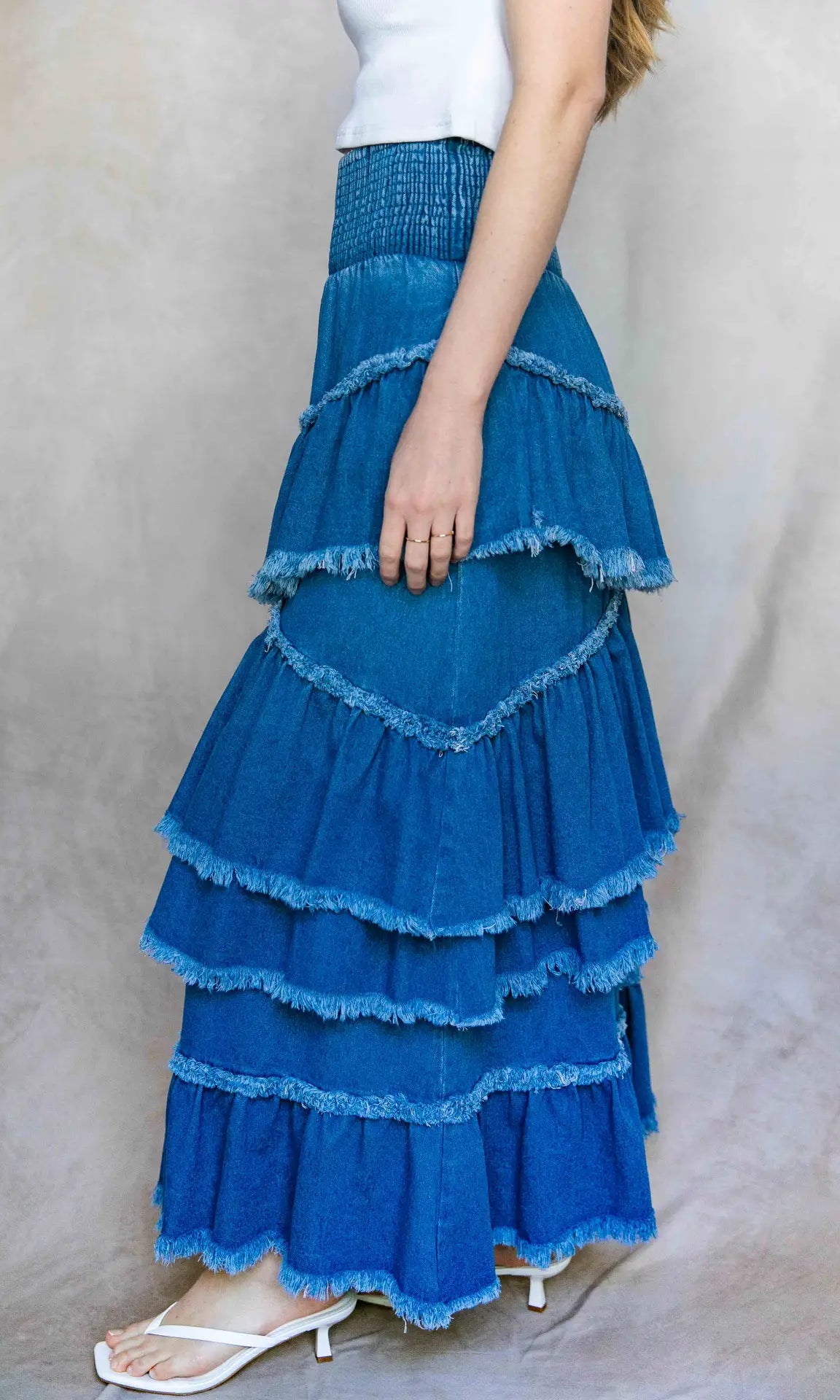 Blue tiered skirt worn by a person on a plain background