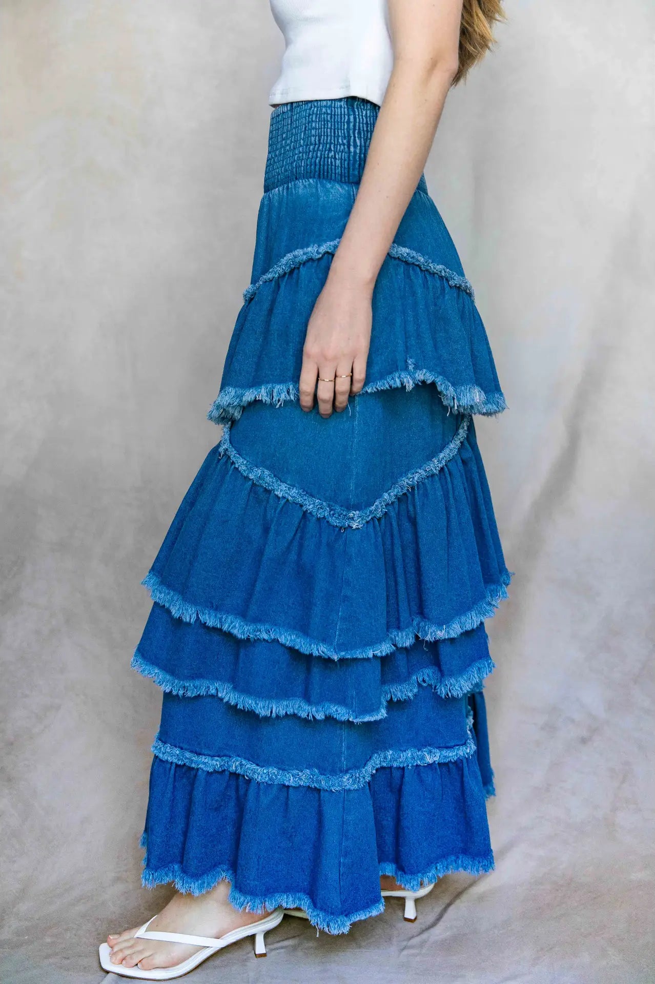 Blue tiered skirt worn by a person on a plain background