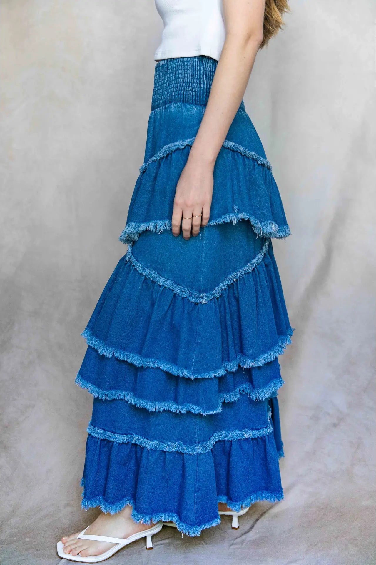 Blue tiered skirt worn by a person on a plain background