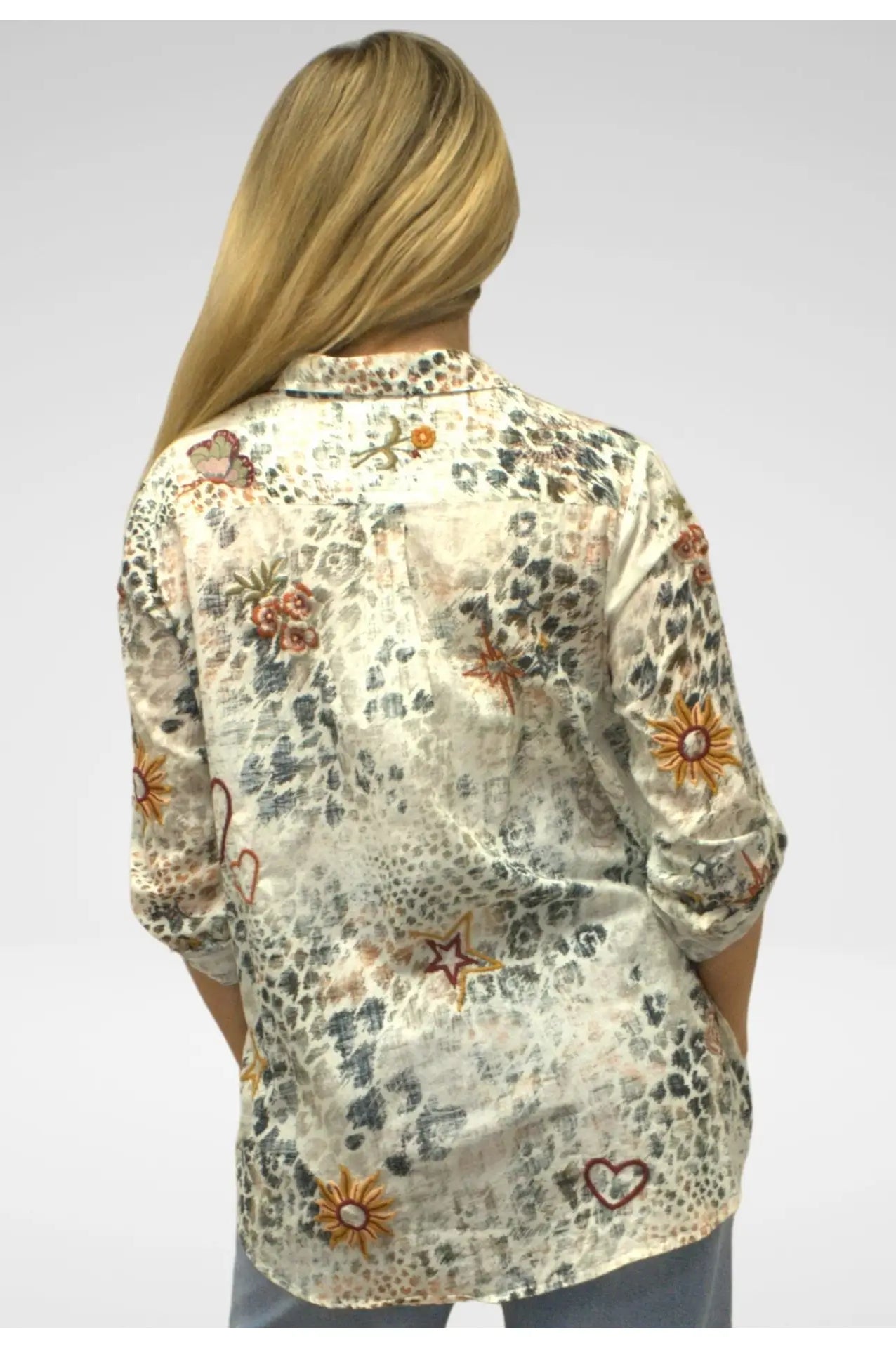Floral patterned shirt worn by a person on a plain background