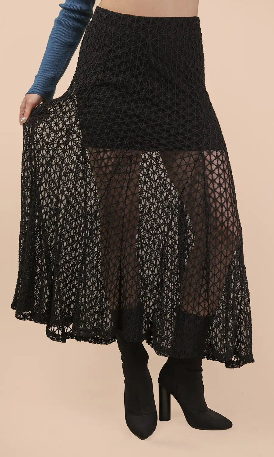 Black lace skirt worn by a person on a beige background