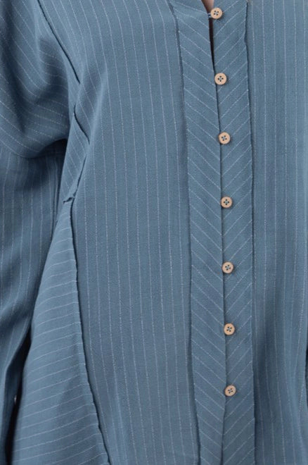 Close-up of dusty-blue striped shirt placket and chevron pinstripe detail with wooden buttons.