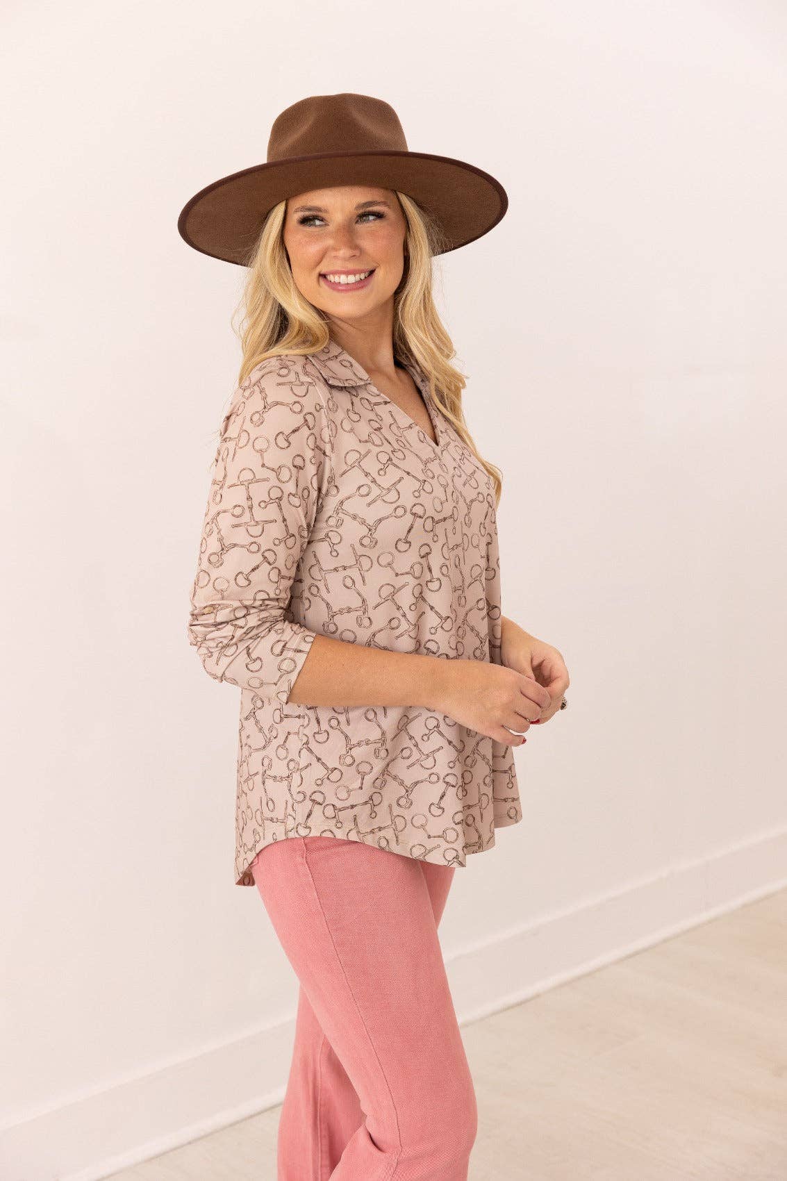 Front view of V-neck stretch top with roll-tab sleeves in a relaxed fit tan with brown horse bit pattern all over top