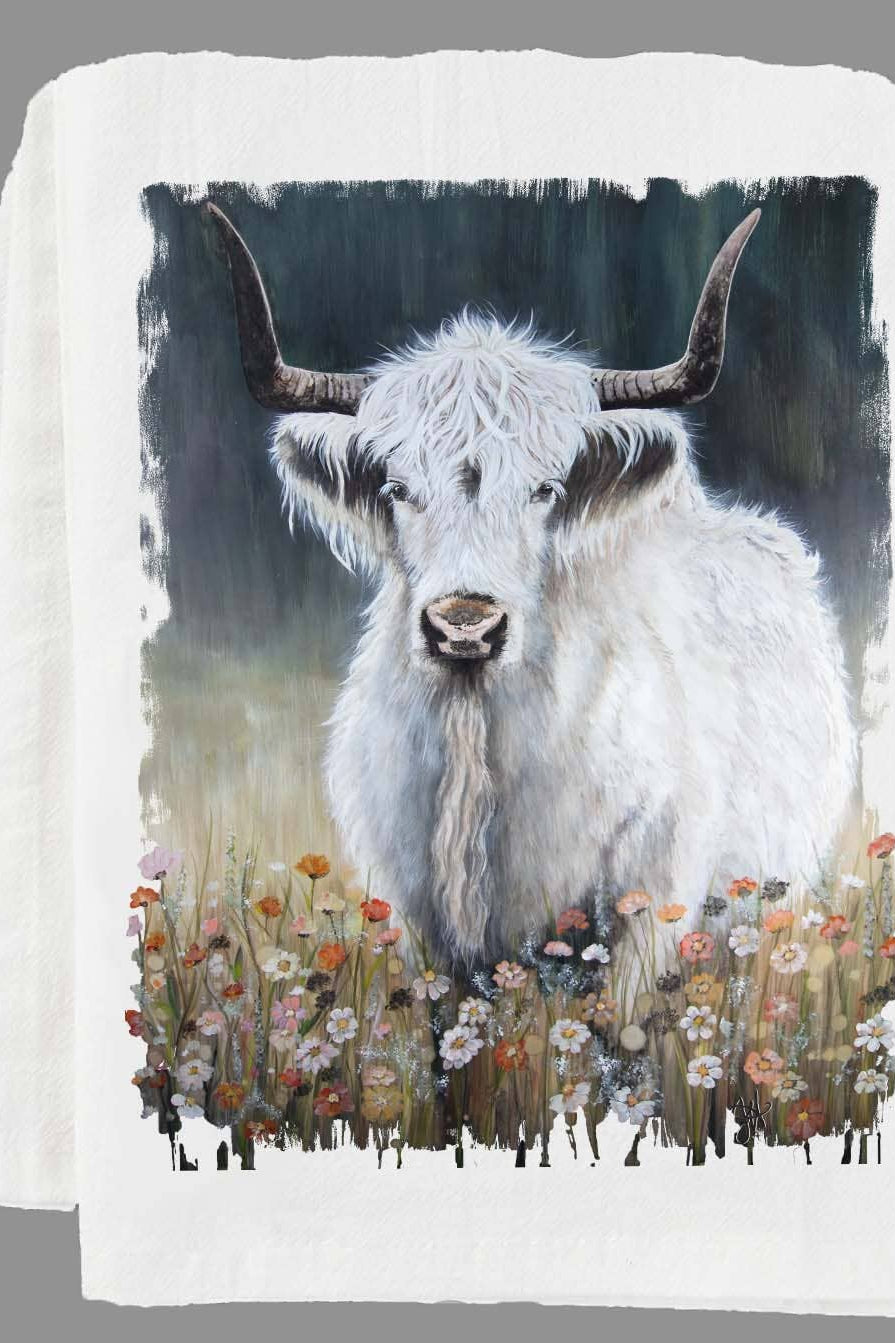 Folded kitchen towel with a highland cow design on a gray background