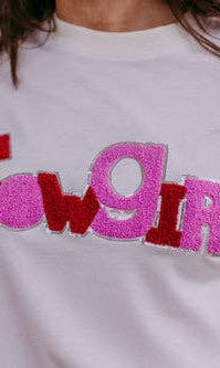 White sweatshirt with 'Cowgirl' text in red and pink on a blurred background
