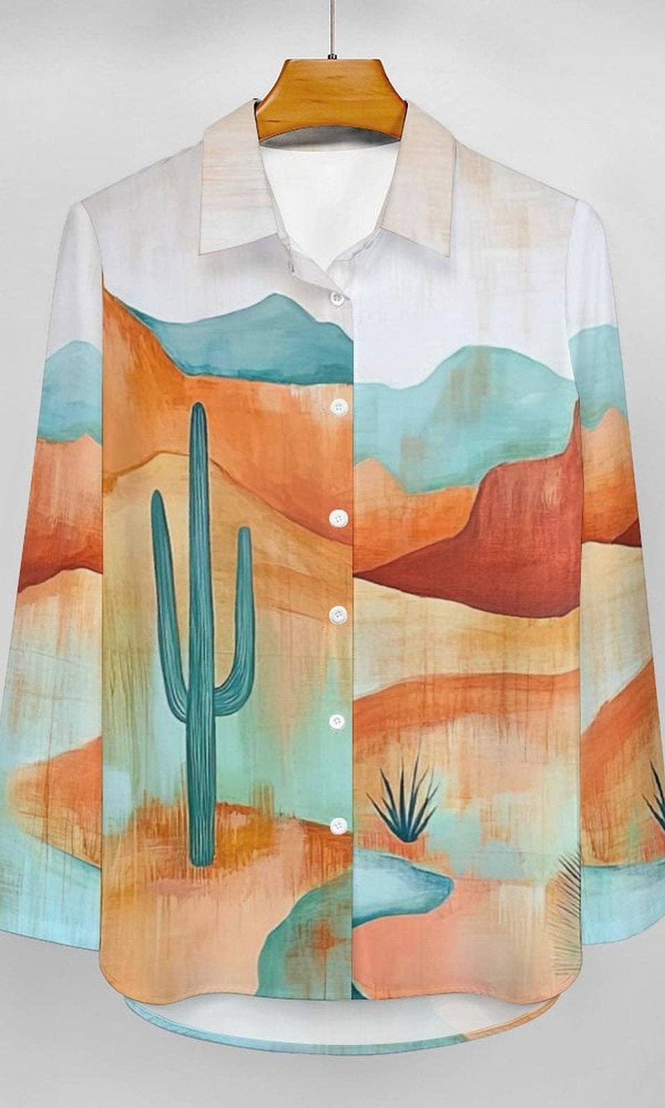 Colorful shirt with desert landscape design on a hanger against a white background