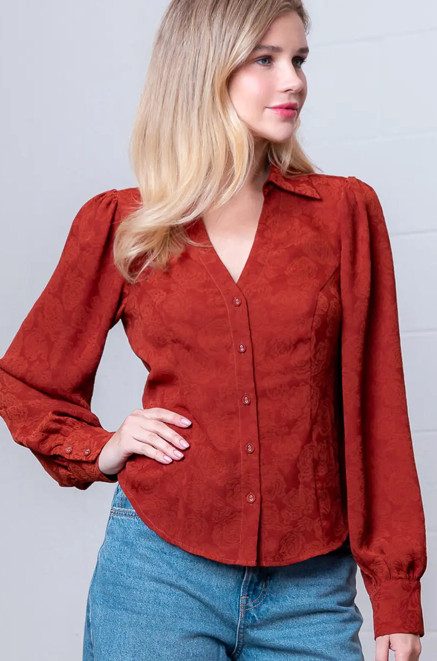 Front view of rust Western-inspired embossed blouse showing tailored waist and button front.
