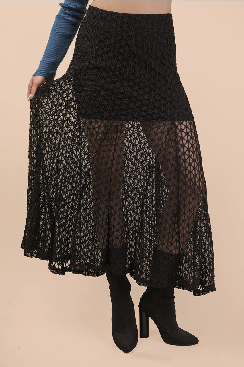 Black lace skirt worn by a person on a beige background