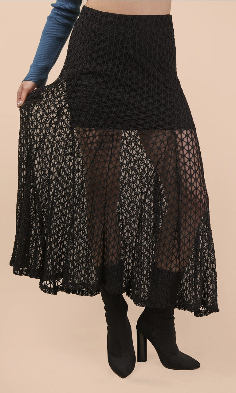 Black lace skirt worn by a person on a beige background