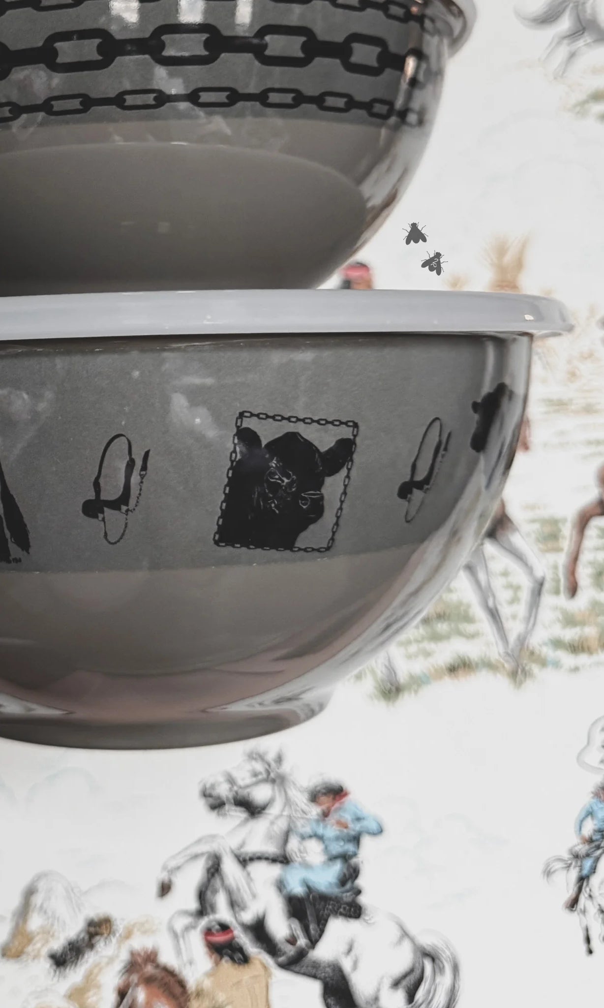Close-up of a bowl with black angus cow designs on a textured surface with illustrations.