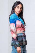 Woman wearing a colorful jacket with a plain background