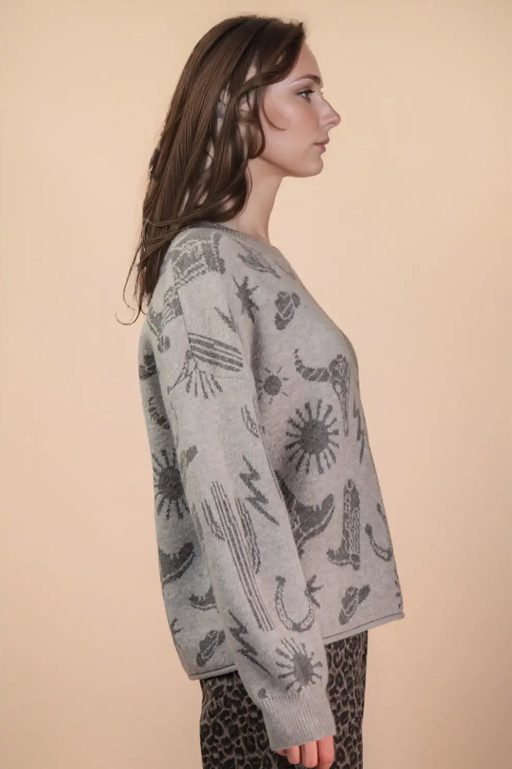 Side angle showing relaxed drape and long sleeves on grey western graphic sweater