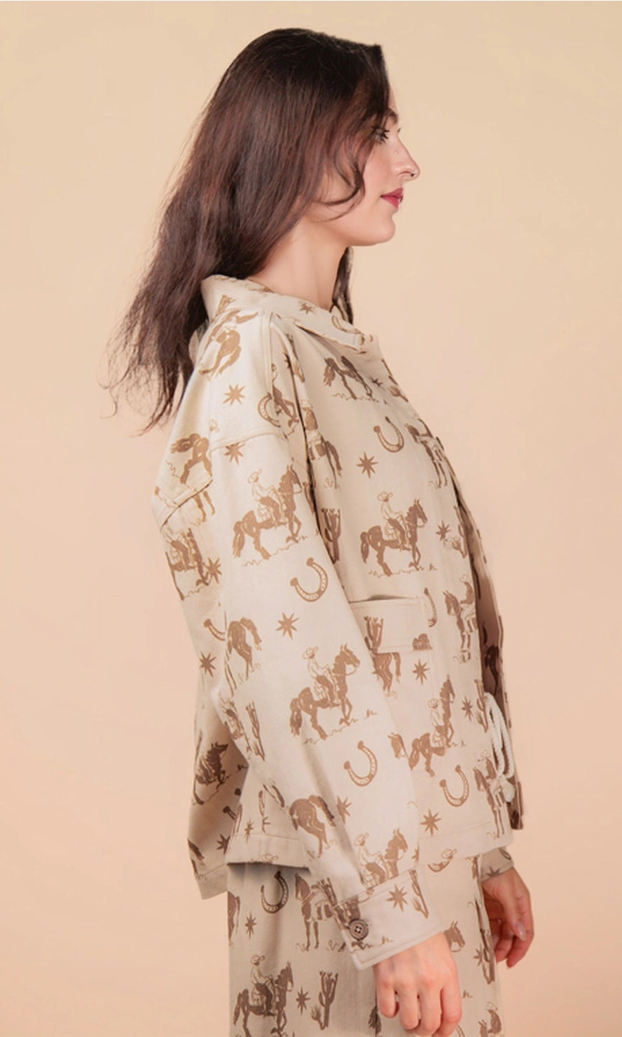 Woman wearing a beige outfit with horse pattern on a beige background